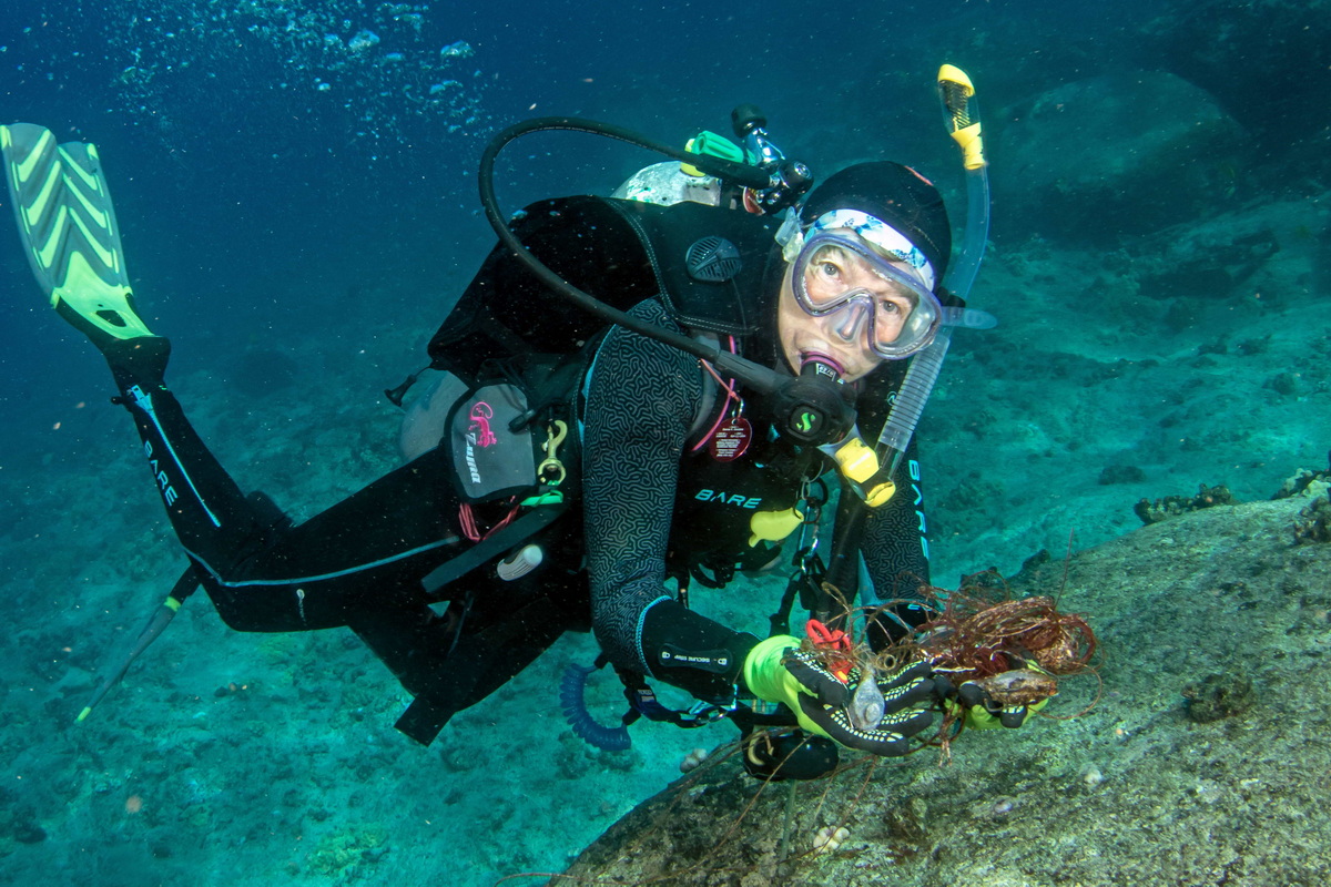 ODA volunteer collects ocean debris for proper disposal.
